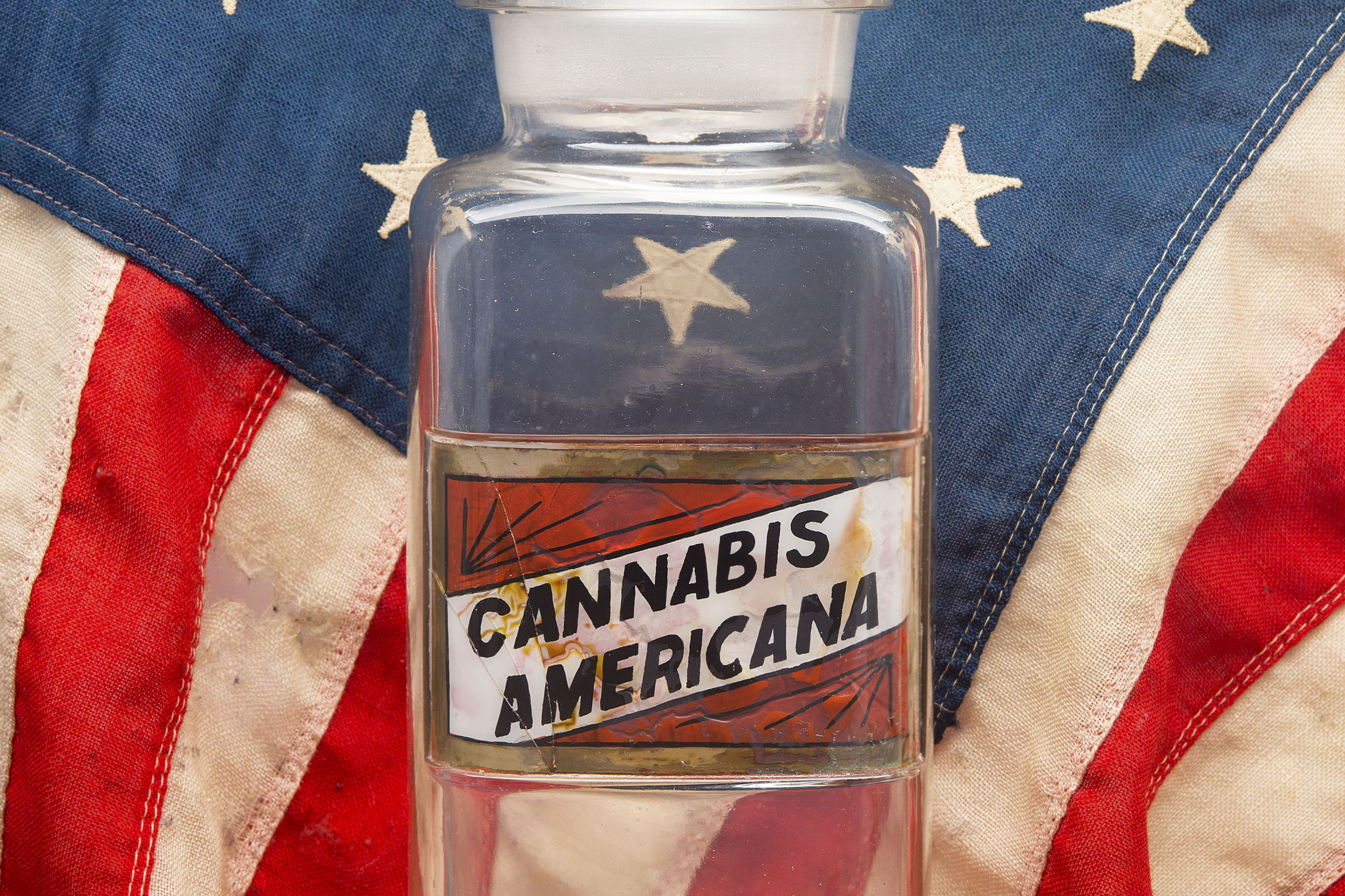 Cannabis Americana Image of Glass Container with American Flag Background